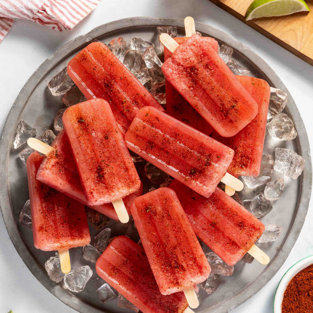 Popsicles on a bed of ice surrounded by fresh watermelon