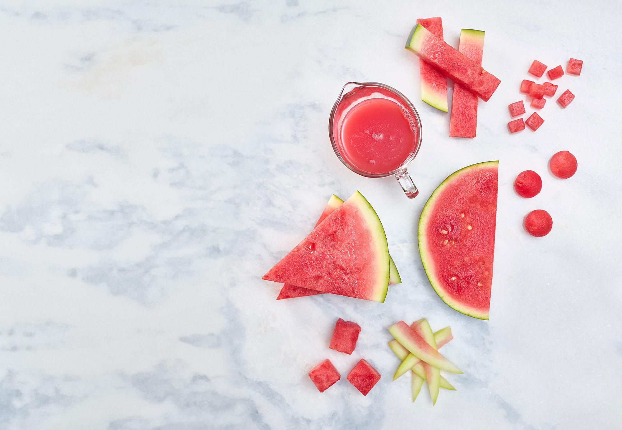 Watermelon cuts and cubes on a marble background