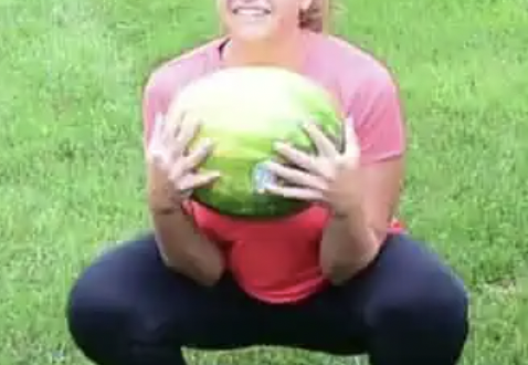 Girl in a squat holding watermelon
