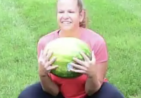 Girl in a squat holding watermelon
