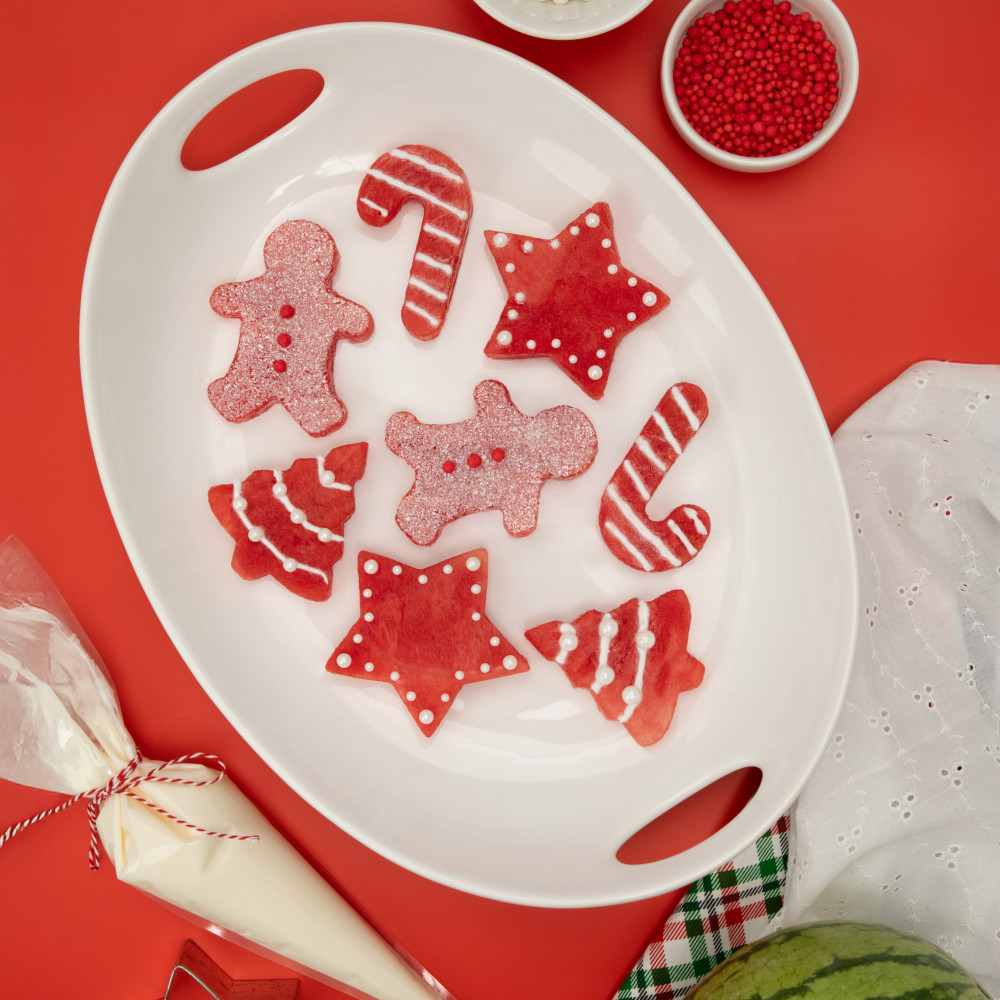 holiday themed watermelon cut outs with frosting arranged on a plate