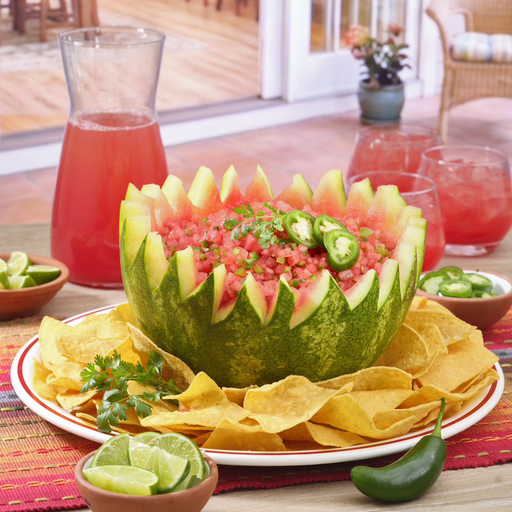Half a watermelon filled with watermelon salsa and slices of jalapeño.