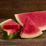 watermelon slices and half moon on brown wood background